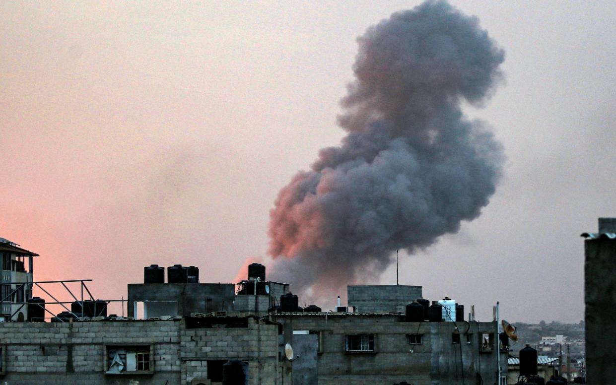 Smoke rises above buildings during an early morning Israeli strike