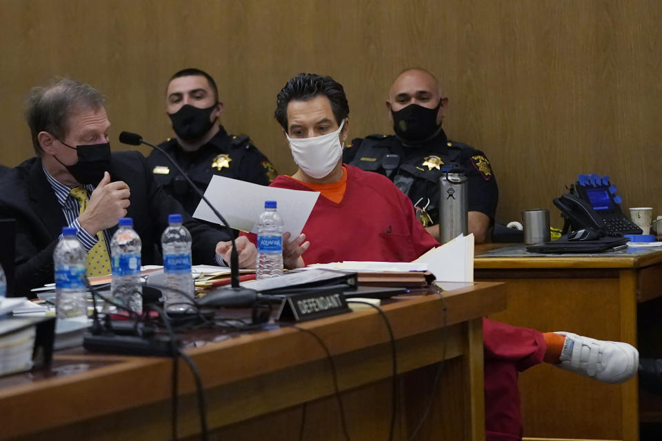 Scott Peterson, middle, hands paper to attorney Cliff Gardner during a hearing at the San Mateo County Superior Court in Redwood City, Calif., Monday, Feb. 28, 2022. In 2004, Peterson was convicted of the murders of his wife, Laci Peterson, 27, who was eight months pregnant, and of the unborn son they planned to name Conner. (AP Photo/Jeff Chiu, Pool)