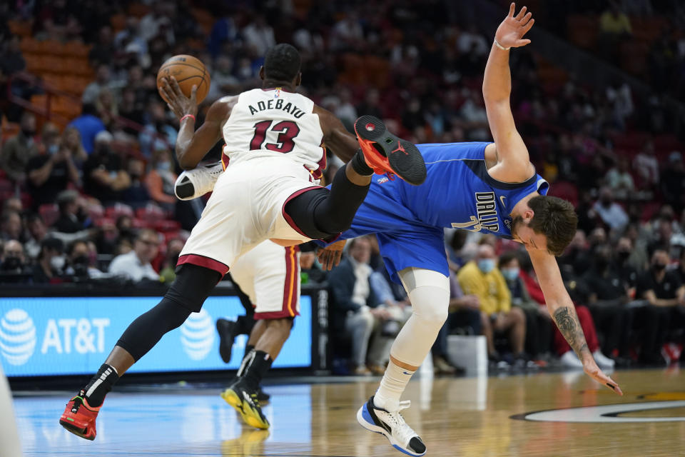 Miami Heat center Bam Adebayo (13) and Dallas Mavericks guard Luka Doncic collide as they vie for a loose ball during the first half of an NBA basketball game, Tuesday, Feb. 15, 2022, in Miami. (AP Photo/Wilfredo Lee)