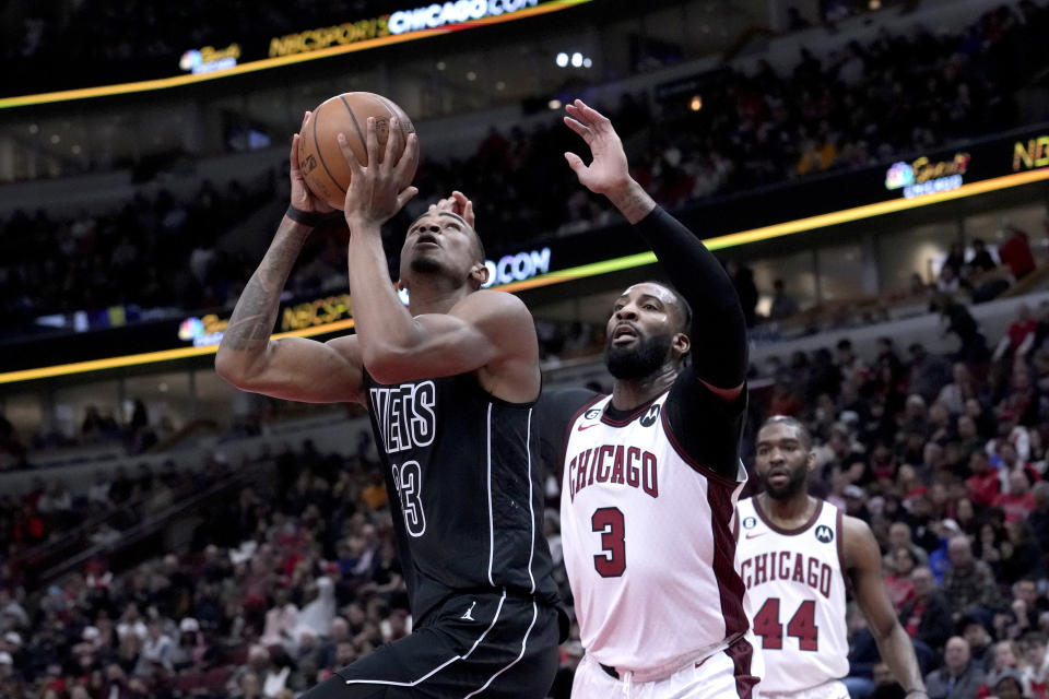 Brooklyn Nets' Nic Claxton (33) drives to the basket as Chicago Bulls' Andre Drummond (3) defends during the first half of an NBA basketball game Friday, Feb. 24, 2023, in Chicago. (AP Photo/Charles Rex Arbogast)