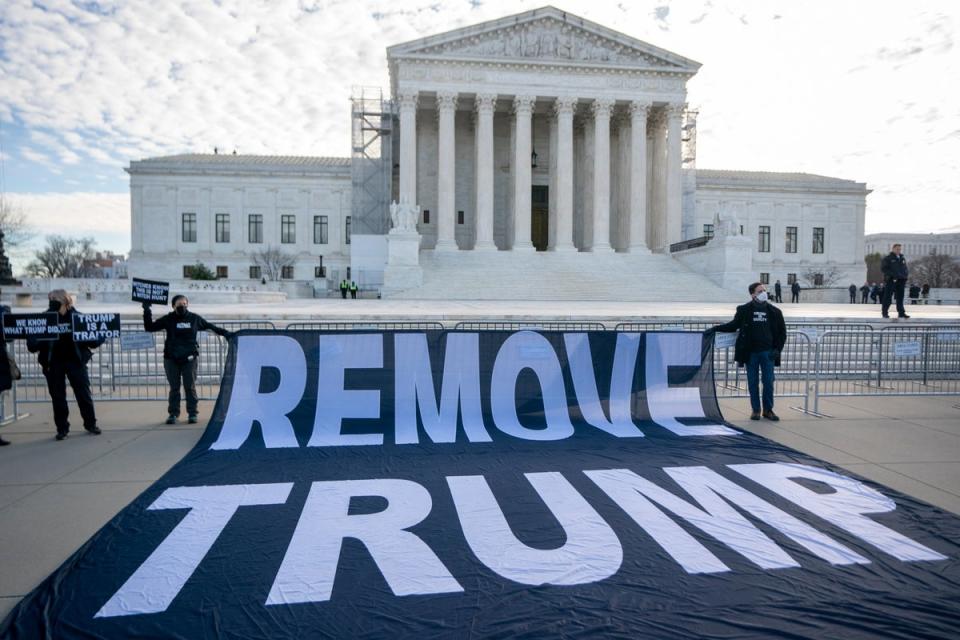 Protesters hold a ‘remove Trump’ banner outside the US Supreme Court on 8 February as justices hear arguments in case considering whether to disqualify the former president from office. (EPA)