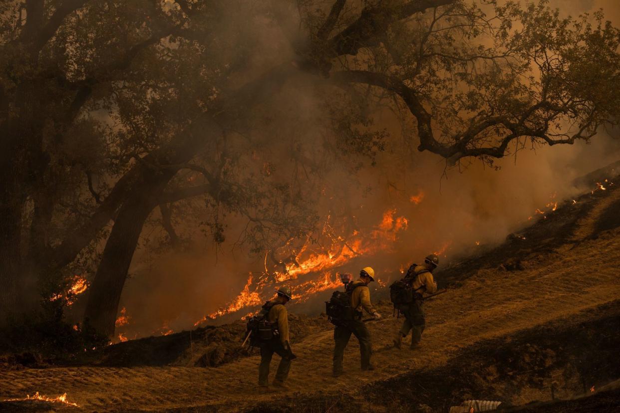 Firefighters watch over a back fire along a hillside during firefighting operations to battle the Kincade Fire in Healdsburg, Calif. on Oct. 26, 2019.