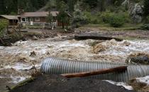 A home is stranded after a flash flood in Coal Creek destroyed the bridge near Golden, Colorado September 12, 2013. Flooding in Colorado left two people dead, prompted hundreds to be evacuated, caused building collapses and stranded cars, officials said. (REUTERS/Rick Wilking)