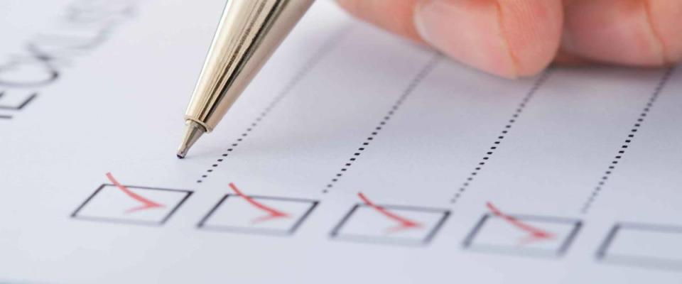 Cropped image of businessman preparing checklist at office desk