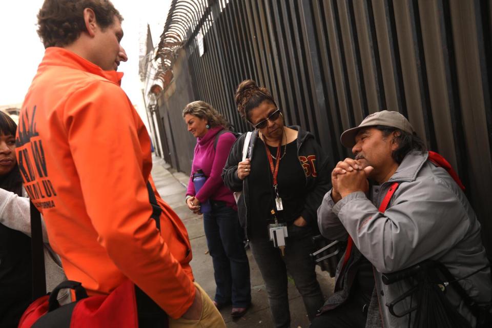 Dr. Steven Hochman, left, Dr. Susan Partovi and Sylvia Meza check on the well-being of a man in downtown L.A.