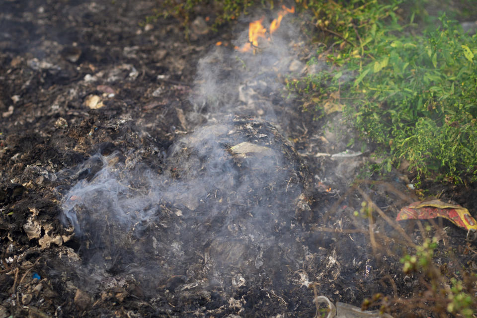 a shot of Garbage pile burning causing air pollution