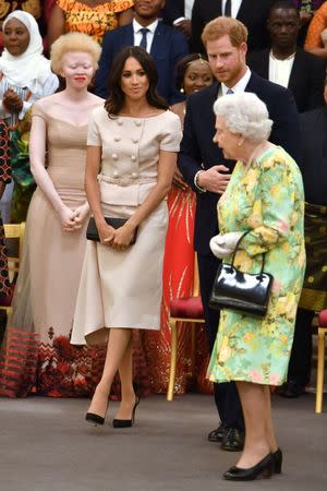 Britain's Queen Elizabeth, Prince Harry and Meghan, the Duchess of Sussex attend reception following the final Queen's Young Leaders Awards Ceremony at Buckingham Palace in London, Britain June 26, 2018. John Stillwell/Pool via Reuters