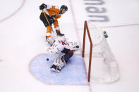 Washington Capitals goaltender Braden Holtby (70) makes a stop on Philadelphia Flyers center Scott Laughton (21) during the second period of an NHL hockey playoff game Thursday, Aug. 6, 2020, in Toronto. (Cole Burston/The Canadian Press via AP)
