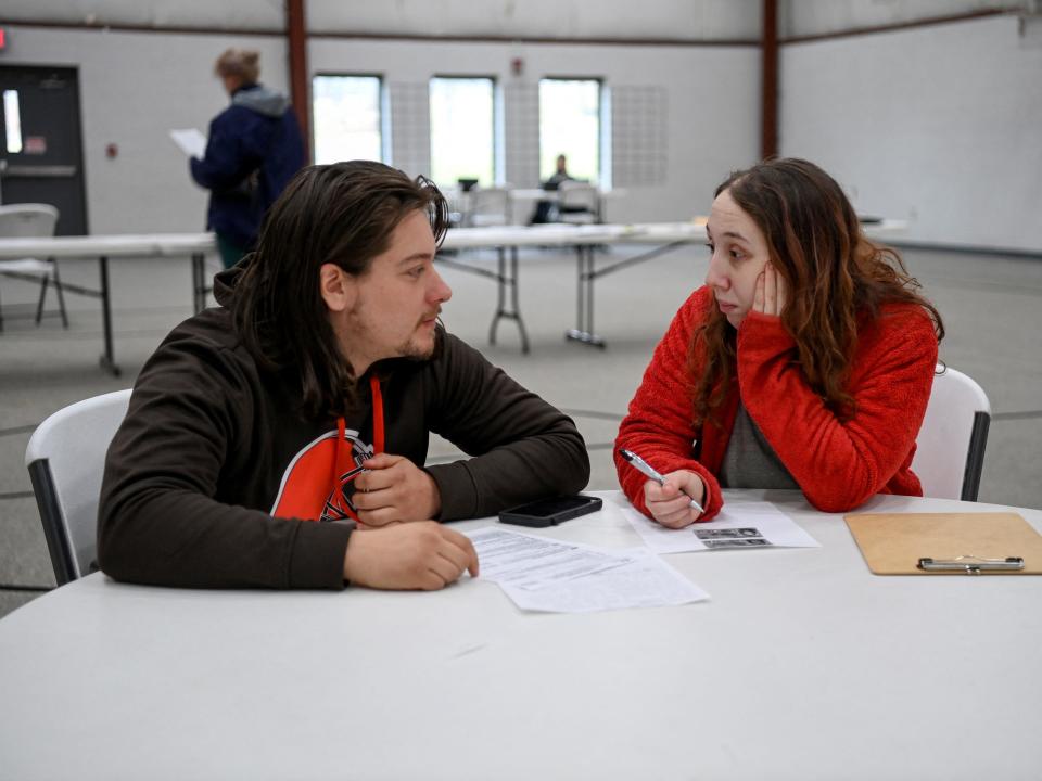 Two residents fill out forms for reimbursement after the crash in East Palestine, Ohio.