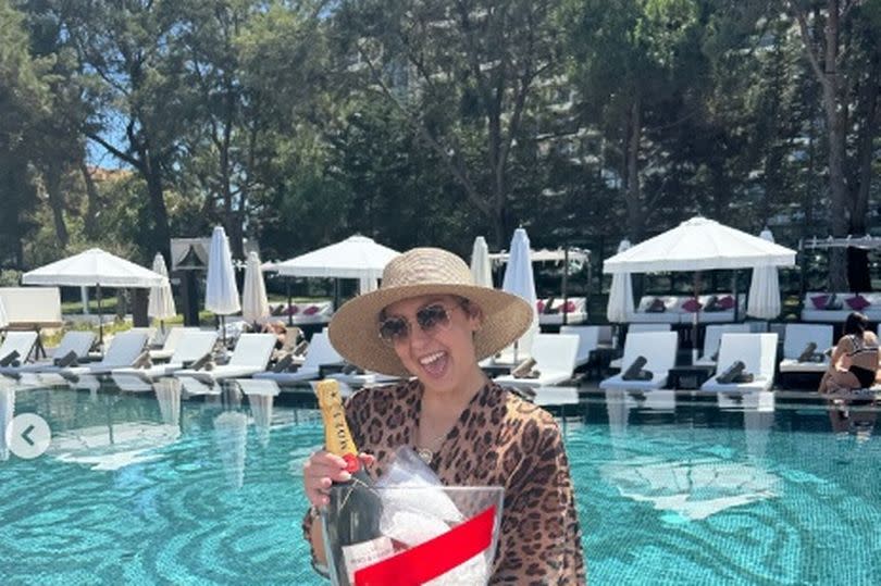 Amy posed with a bottle of champagne while enjoying her holiday