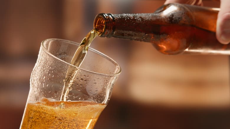 Hand pouring beer into glass