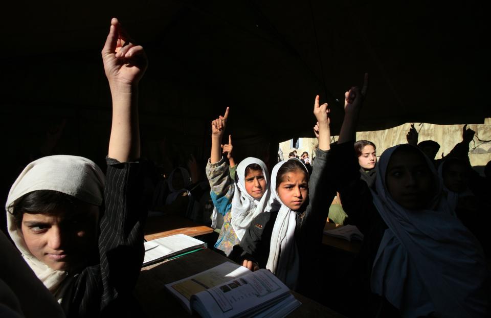 Afghan girls raise their hands during english class at the Bibi Mahroo high school in Kabul, Afghanistan November 22, 2006. (Paula Bronstein/Getty Images)