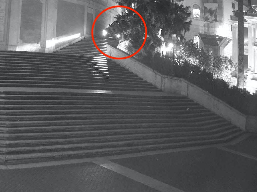 A Maserati, circled, drives down Rome's Spanish Steps.