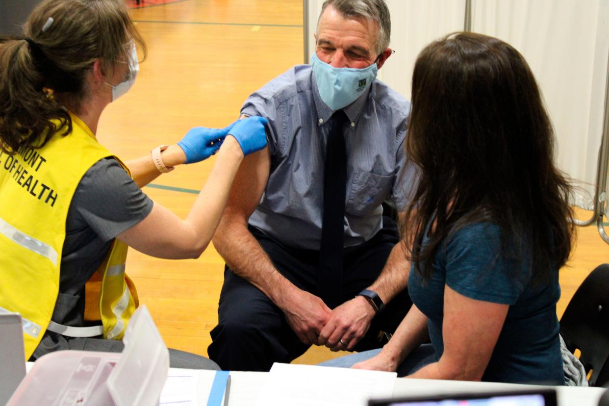 In this photo provided by the State of Vermont, Vermont Gov. Phil Scott, center, receives a COVID-19 vaccine as his wife, Diana McTeague Scott, right, looks on, Monday, April 5, 2021, at Montpelier High School in Montpelier, Vt. Scott, a Republican, and his wife got the single-dose Johnson & Johnson shot at a state-run clinic at the school.