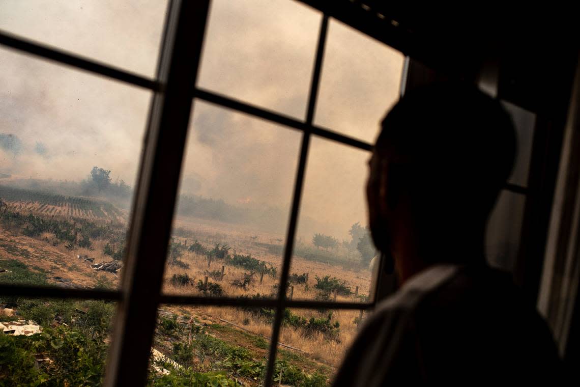 A resident looks as flames advance during a wildfire in Pumarejo de Tera in north western Spain, Monday, July 18, 2022. Firefighters battled wildfires raging out of control in Spain and France as Europe wilted under an unusually extreme heat wave that authorities in Madrid blamed for hundreds of deaths. (AP Photo/Emilio Fraile)