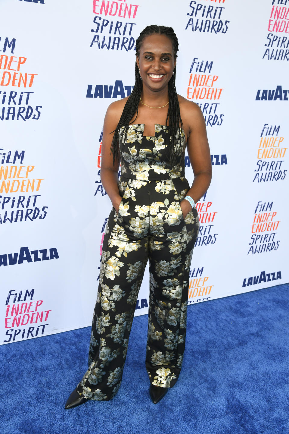 Monique in a floral jumpsuit poses at the Film Independent Spirit Awards