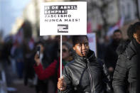 A girl carries a poster with the words "April 25 always, Fascism never again!" during a demonstration against racism in Lisbon, Portugal, Saturday, Feb. 24, 2024. April 25 is the date of the 1974 Carnation Revolution that toppled a rightist dictatorship in Portugal. The demonstration was organized under the slogan "Vote against racism," as an election campaign kicks off ahead of Portugal's March 10 general election. (AP Photo/Armando Franca)