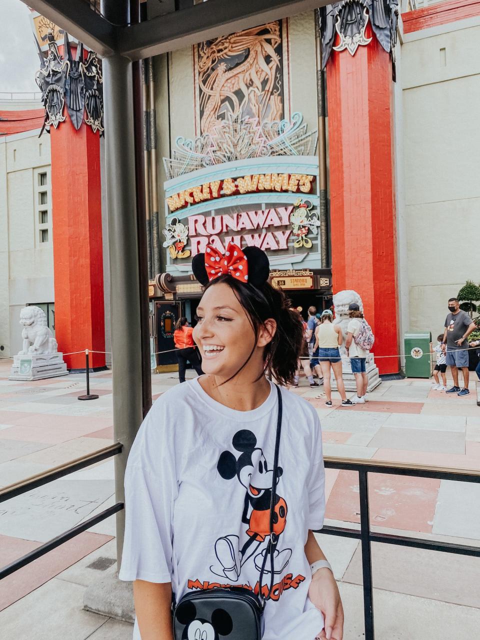 Disney fan Olivia Duce stands in front of Mickey & Minnie's Runaway Railway.