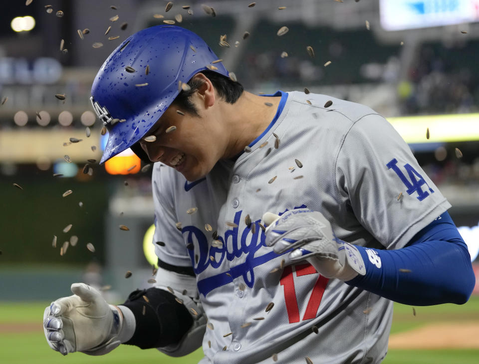 Los Angeles Dodgers designated hitter Shohei Ohtani (17) is doused with sunflower seeds after hitting a solo home run during the seventh inning of a baseball game against the Minnesota Twins, Monday, April 8, 2024, in Minneapolis. (AP Photo/Abbie Parr)