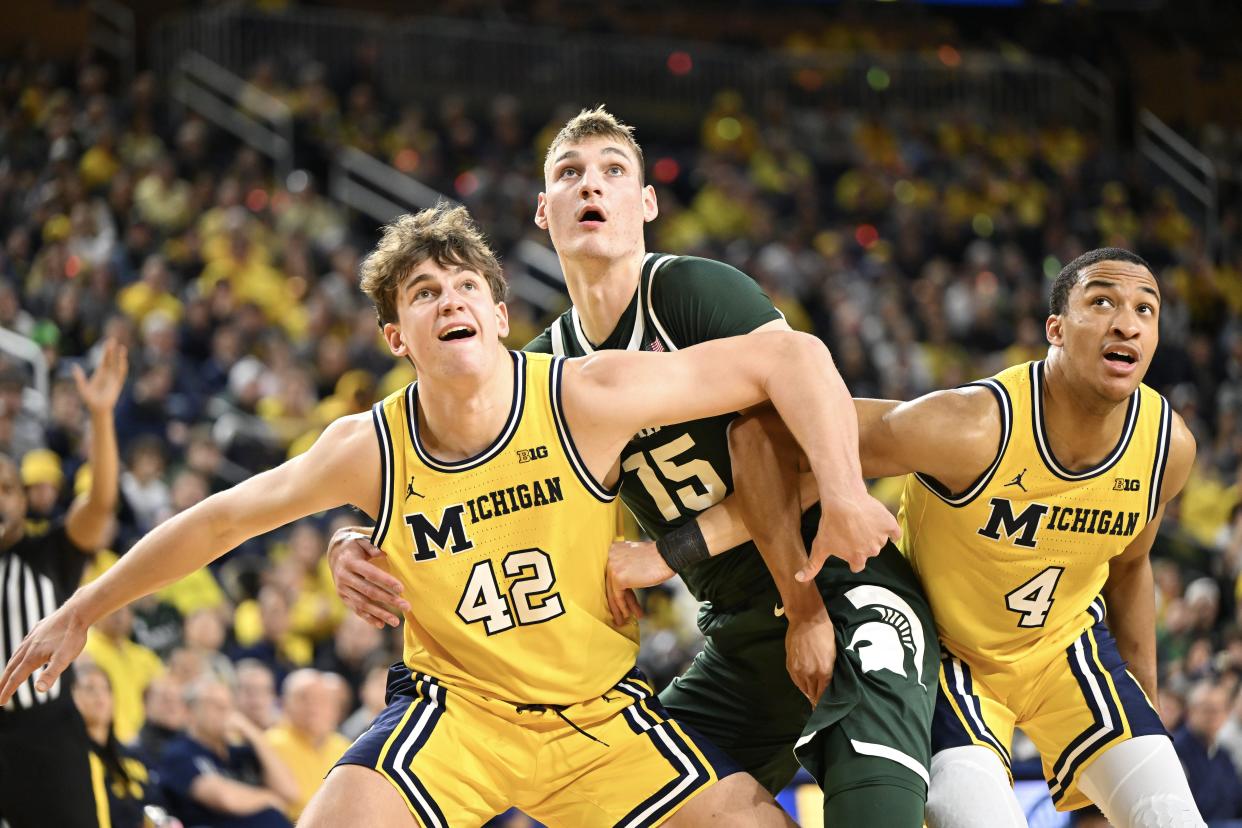 Will Tschetter and Nimari Burnett of the Michigan Wolverines battle for a rebound against Carson Cooper of the Michigan State Spartans in the second half at Crisler Center in Ann Arbor on Saturday, Feb. 17, 2024.