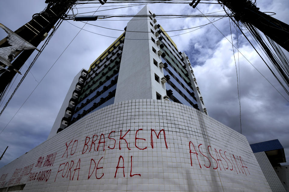 Graffiti that reads in Portuguese; "Braskem out of Alagoas, killer", is scrawled on the facade of an apartment building that has been vacated because of the threat of ground subsidence and geological problems caused by the Braskem mine in Maceio, Alagoas state, Brazil, Monday, March 7, 2022. Braskem is one of the biggest petrochemical companies in the Americas, owned primarily by Brazilian state-run oil company Petrobras and construction giant Novonor, formerly known as Odebrecht. (AP Photo/Eraldo Peres)