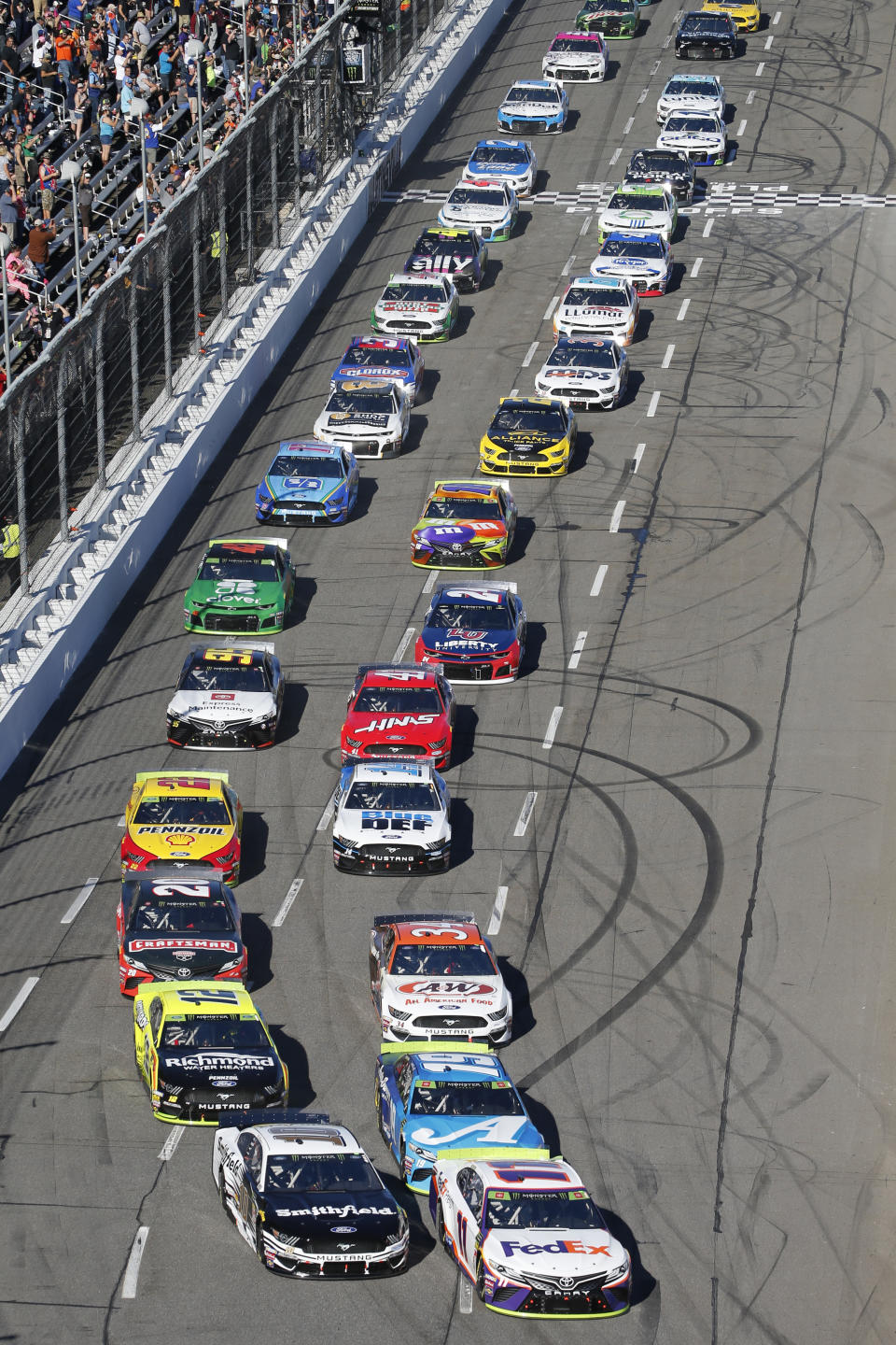 Denny Hamlin (11) leads the field at the start of a NASCAR Cup Series race at Martinsville Speedway in Martinsville, Va., Sunday, Oct. 27, 2019. (AP Photo/Steve Helber)