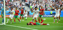 Soccer Football - World Cup - Group B - Morocco vs Iran - Saint Petersburg Stadium, Saint Petersburg, Russia - June 15, 2018 Morocco's Aziz Bouhaddouz looks dejected after scoring an own goal for Iran's first goal as Iran's Mehdi Taremi and Karim Ansarifard celebrate REUTERS/Dylan Martinez