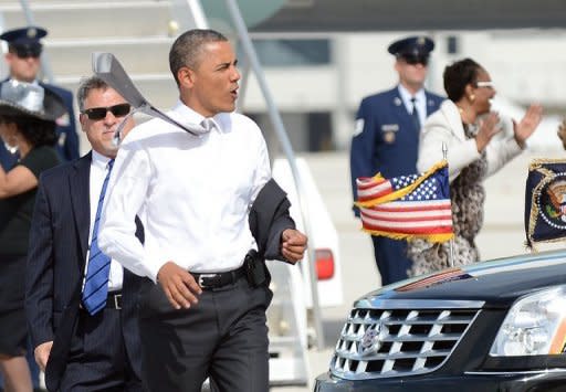 US President Barack Obama takes his coat off as he rushes to greet supporters upon arriving at Miami International Airport in Miami, Florida, on June 26. Obama, renowned as a champion fundraiser who piled up $750 million in 2008, warned supporters he would be outspent by his foe Mitt Romney in this year's election