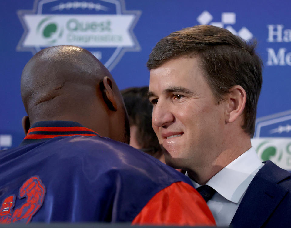 EAST RUTHERFORD, NEW JERSEY - JANUARY 24: Eli Manning of the New York Giants is hugged by former players as he announces his retirement during a press conference on January 24, 2020 at Quest Diagnostic Training Center in East Rutherford, New Jersey.The two time Super Bowl MVP is retiring after 16 seasons with the team. (Photo by Elsa/Getty Images)