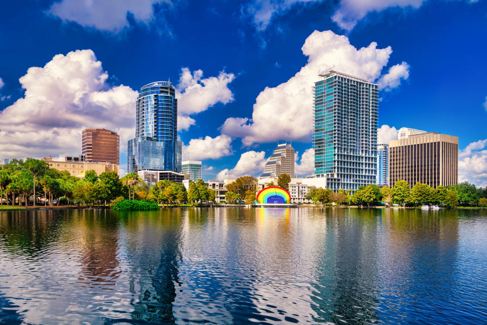 Downtown Orlando highrise buildings with Lake Eola in the foreground and a dramatic sky with cumulus clouds in the background.