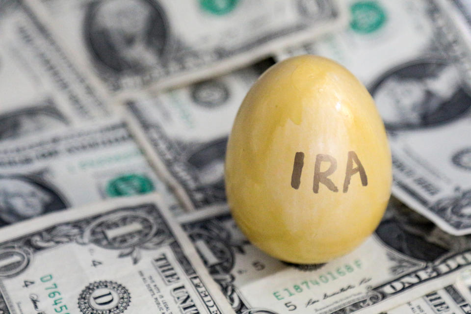 Mustard-colored egg with IRA on it on top of a pile of dollar bills
