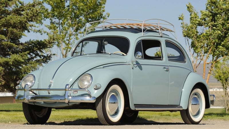 A photo of a pale blue VW Beetle with a wooden roof rack. 