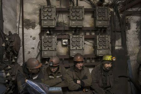 Miners wait at an elevator control room at the Zasyadko coal mine in Donetsk March 4, 2015. REUTERS/Baz Ratner