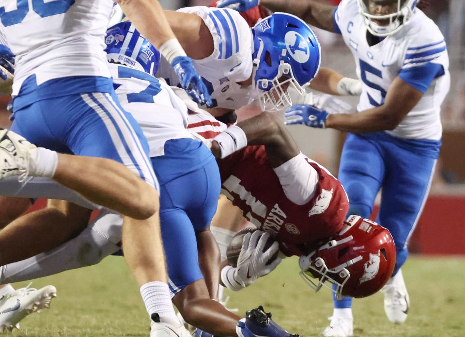 The Brigham Young Cougars defense tackles Arkansas Razorbacks wide receiver Jaedon Wilson (13) at Razorback Stadium in Fayetteville on Saturday, Sept. 16, 2023. BYU won 38-31. | Jeffrey D. Allred, Deseret News