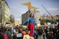 A woman stands on a street bollard and holds a poster as she attends the 'Friday for Future' climate protest in near the Brandenburg Gate in Berlin, Germany, Friday, Sept. 20, 2019. Protests of the 'Fridays For Future' movement against the increase of carbon dioxide emissions are planned Friday in cities around the globe. In the United States more than 800 events are planned Friday, while in Germany more than 400 rallies are expected. (AP Photo/Markus Schreiber)