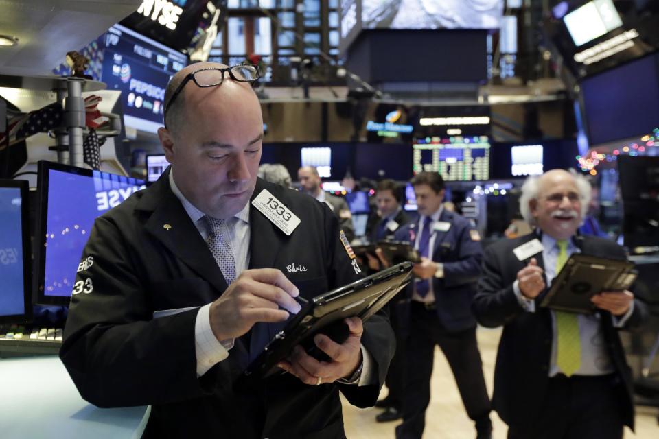 Trader Christopher Morie, left, works on the floor of the New York Stock Exchange, Friday, Dec. 9, 2016. U.S. stocks are opening higher Friday morning as major indexes continue to set records. (AP Photo/Richard Drew)