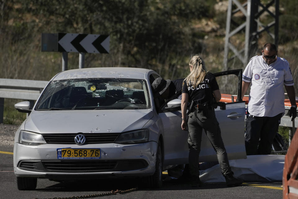 Israeli security forces examine the scene of a Palestinian shooting attack, near Wadi al-Haramiya, West Bank, Sunday, Jan. 7, 2024. A Palestinian resident of Jerusalem who presumably was mistaken by the assailants as an Israeli because of the Israeli car license plates was fatally shot in the shooting, the Magen David Adom rescue service said. (AP Photo/Leo Correa)