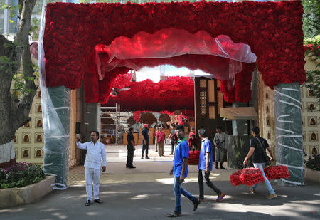 A man carries bunches of artificial flowers to decorate Antilia, the house of the Chairman of Reliance Industries Mukesh Ambani, ahead of his daughter's wedding, in Mumbai, India, December 7, 2018. REUTERS/Francis Mascarenhas