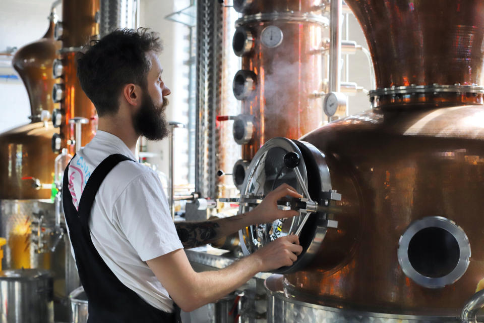 Distiller Sam Garbutt checks distillery controls in the East London Liquor Company in London, in 2018. Many people now like to know more about their food and drink and where it comes from, leading to a boom in so-called "spirit tourism’’ in Britain, with artisan brands and micro distilleries popping up across the country. (East London Liquor Company via AP)