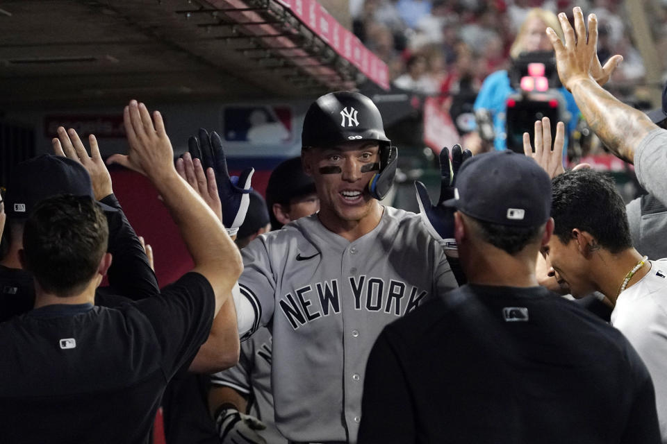 New York Yankees' Aaron Judge is congratulated by teammates in the dugout after hitting a three-run home run during the fourth inning of a baseball game against the Los Angeles Angels Tuesday, Aug. 30, 2022, in Anaheim, Calif. (AP Photo/Mark J. Terrill)