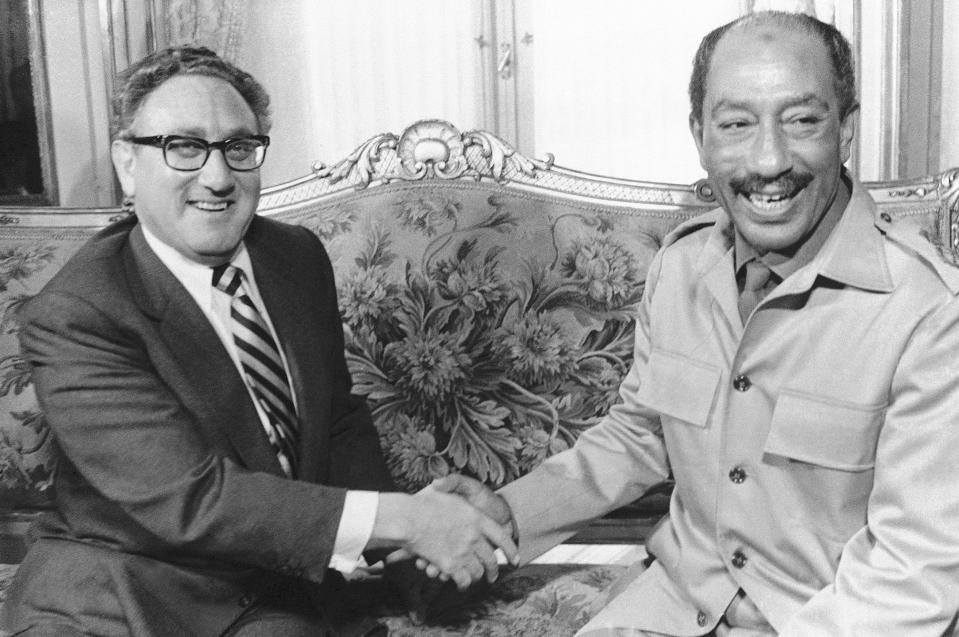 FILE - U.S. Secretary of State Henry Kissinger, left, shakes hands with Egypt's President Anwar Sadat at Tahira Palace in Cairo, Egypt during their meeting on the Mideast crisis, Nov. 7, 1973. Henry Kissinger's legacy in the Mideast is the pursuit of what's possible, not necessarily peace, in one of the world's most intractable conflicts. The former U.S. secretary of state, who died this week at age 100, did just that after Egypt and Syria pulled of a surprise invasion of Israel 50 years ago. (AP Photo/File)