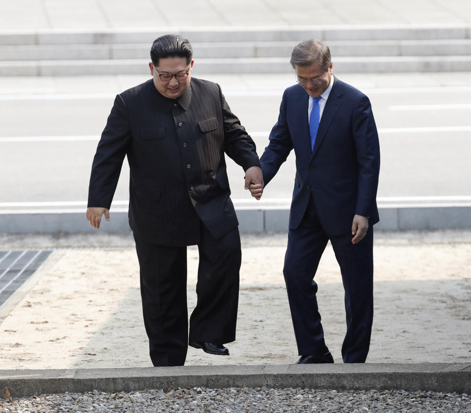 FILE - In this April 27, 2018 file photo, North Korean leader Kim Jong Un, left, and South Korean President Moon Jae-in cross the border line at the border village of Panmunjom in Demilitarized Zone. South Korea’s liberal president faces growing skepticism at home about his engagement policy ahead of his third summit with North Korean leader Kim Jong Un. A survey showed nearly half of South Koreans think next week’s summit won’t find a breakthrough to resolve a troubled nuclear diplomacy. It comes as Moon’s approval rating is declining amid economic frustrations.(Korea Summit Press Pool via AP, File)