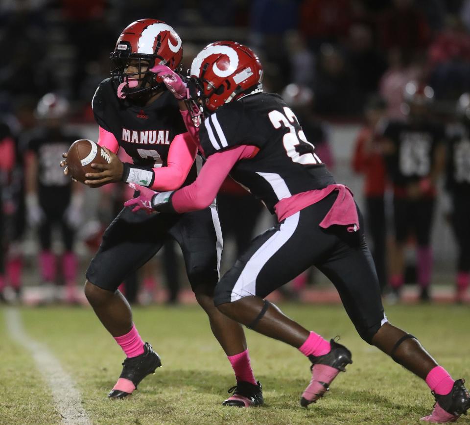 Manual quarterback Tyree Stoner hands off to ZahRon Washburn in the first half against PRP