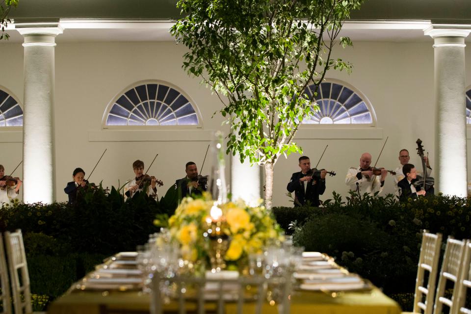 A table is set as a military band plays during a media preview for the State Dinner with President Donald Trump and Australian Prime Minister Scott Morrison in the Rose Garden of the White House, Thursday, Sept. 19, 2019, in Washington.