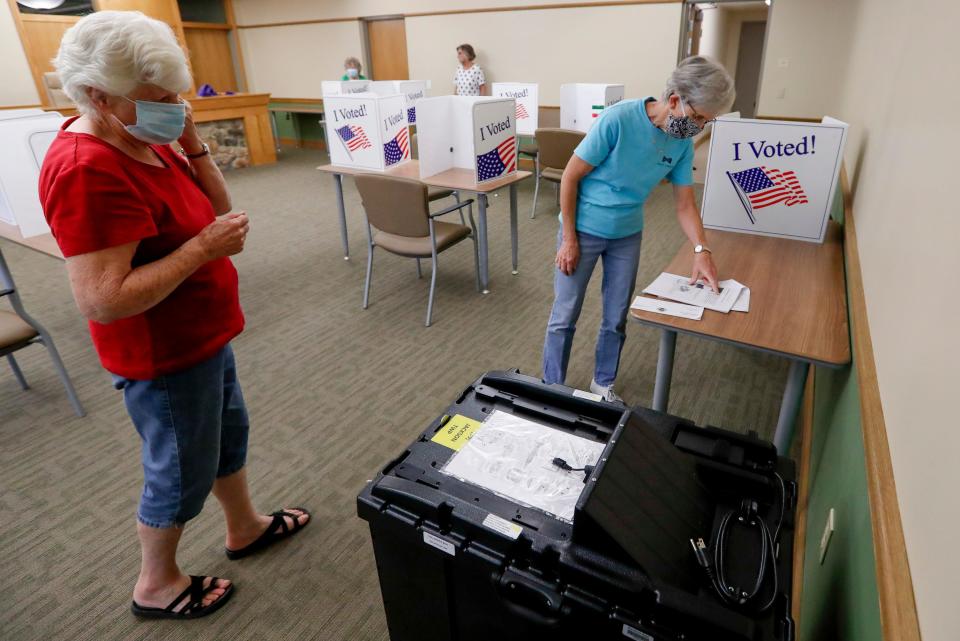 Kay Thiebaud, left, and Lynn Meyers check procedure as they start to set up one of the scanners used in tabulating the vote as they start to set up their polling place Monday, June 1, 2020, for the voting for Tuesday's Pennsylvania primary, in Jackson Township near Zelienople, Pa. (AP Photo/Keith Srakocic)