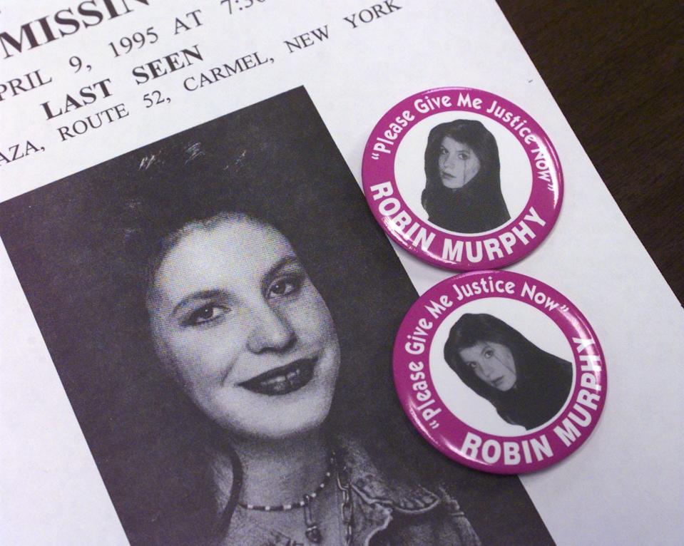 Buttons with Robin Murphy's picture on them sit on a missing person's poster. Murphy, 17, of Lake Carmel was last seen on April 9, 1995.