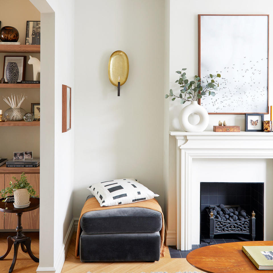 white broken plan living room with wooden floor and grey ottoman fireplace