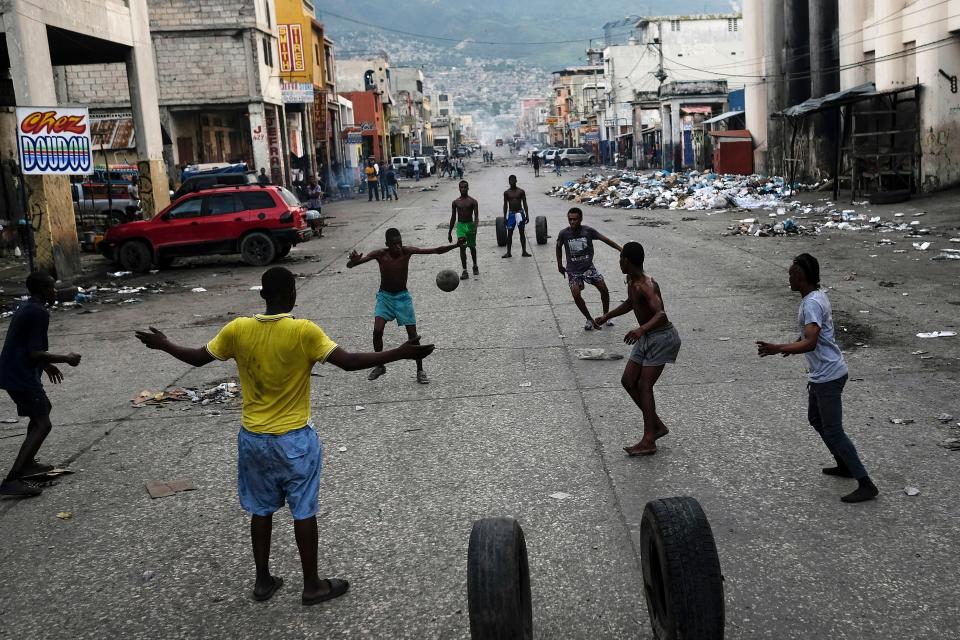 Youths play soccer next to businesses that are closed due to a general strike in Port-au-Prince, Haiti, Monday, Oct. 18, 2021.