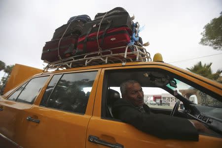 A Palestinian man returning to Gaza looks out as he sits in a car at the Rafah border crossing between Egypt and southern Gaza Strip November 26, 2014. REUTERS/Ibraheem Abu Mustafa