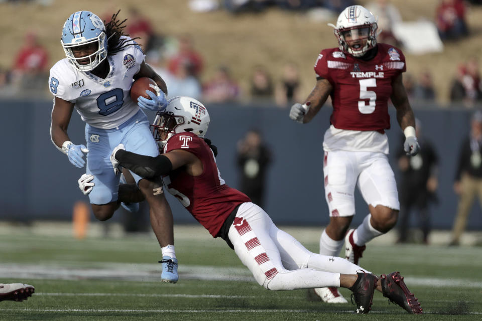 Temple safety Amir Tyler, center, makes a hit on North Carolina running back Michael Carter (8) as Temples' Shaun Bradley (5) looks on during the first half of the Military Bowl NCAA college football game, Friday, Dec. 27, 2019, in Annapolis, Md. (AP Photo/Julio Cortez)